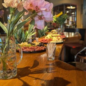 Buffet mit Wurst, Käse und Weintrauben sowie rosa Blumendekoration im Wirtshaus Ausspann´