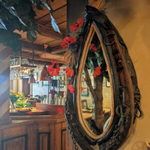 Spiegel in einem historischen Pferdekummet mit roten Blumen im Wirtshaus Ausspann´