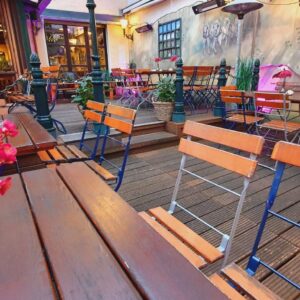Gemütliche Innenhofterrasse mit Holztischen, Stühlen und Blumendekoration im Wirtshaus Ausspann´
