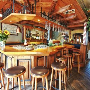 Rustikale Holztheke mit Barhockern und Sonnenblumen im Wirtshaus Ausspann´