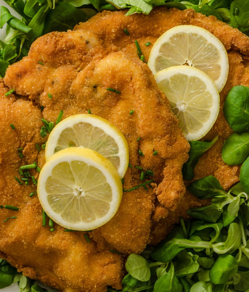 Paniertes Schnitzel mit Zitronenscheiben und Feldsalat im Wirtshaus Ausspann´