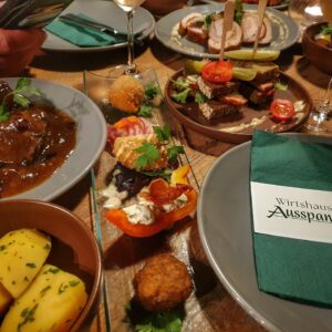 Auswahl verschiedener Wirtshaus-Tapas mit geschmorten Wildschweinwürfeln, gefüllten Hähnchenbrustscheiben und Mini-Leberkäse-Sandwiches im Wirtshaus Ausspann´