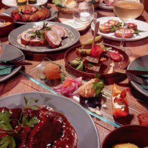 Gedeckter Tisch mit verschiedenen Wirtshaus-Tapas, Kartoffeln und Weißwein im Wirtshaus Ausspann´