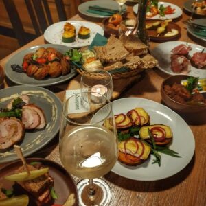 Gedeckter Tisch mit verschiedenen Wirtshaus-Tapas, Brot und Weißwein im Wirtshaus Ausspann´